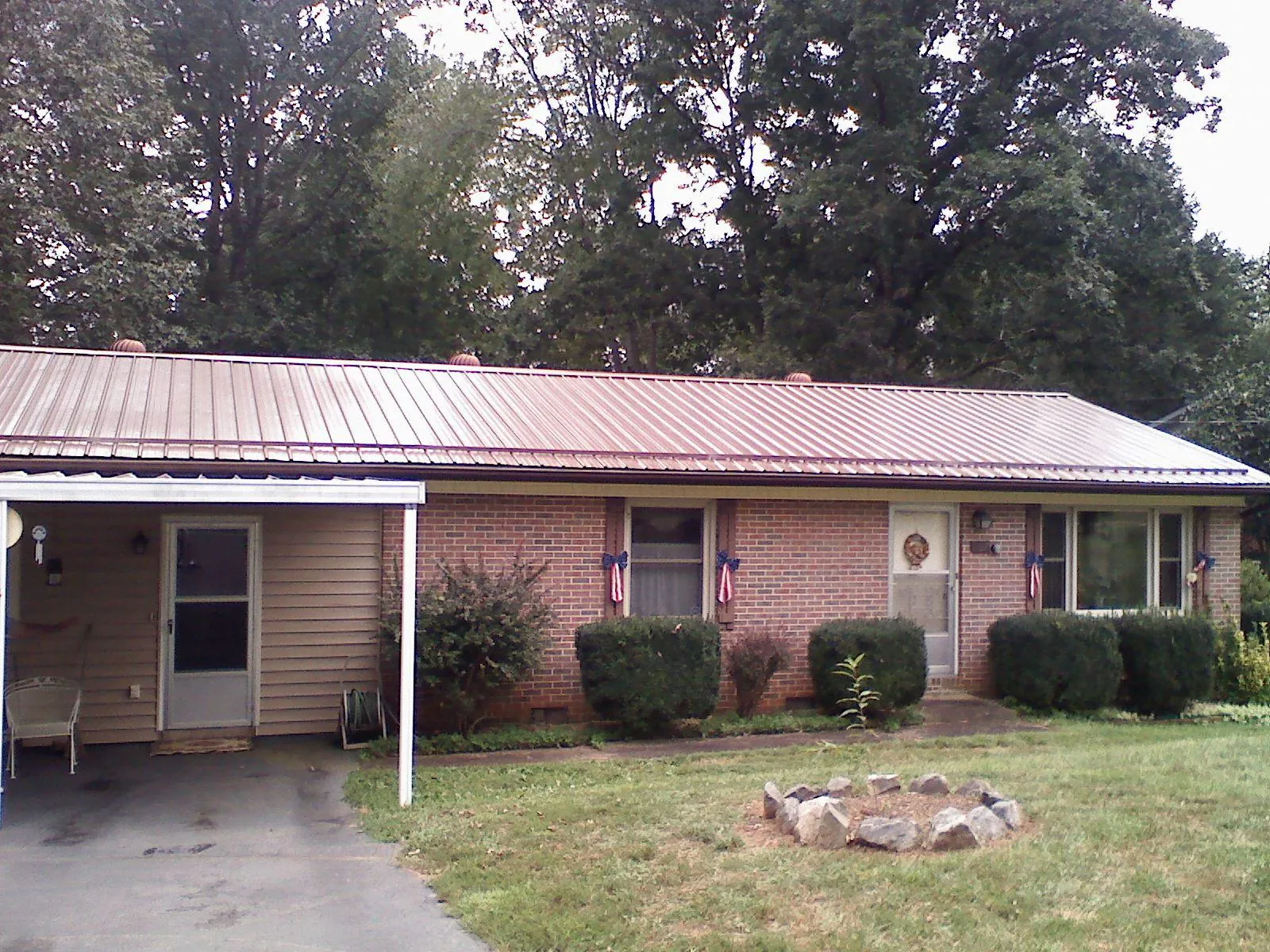 Bronze metal roof and carport on a brick ranch home — Roof Repair work by our crew in Melville